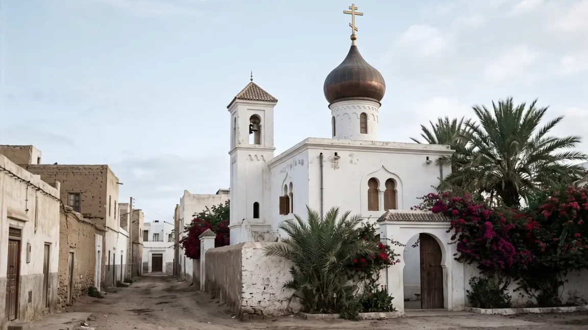Белый православный храм с луковичной главой и звонницей среди пальм и бугенвиллей в марокканском городе